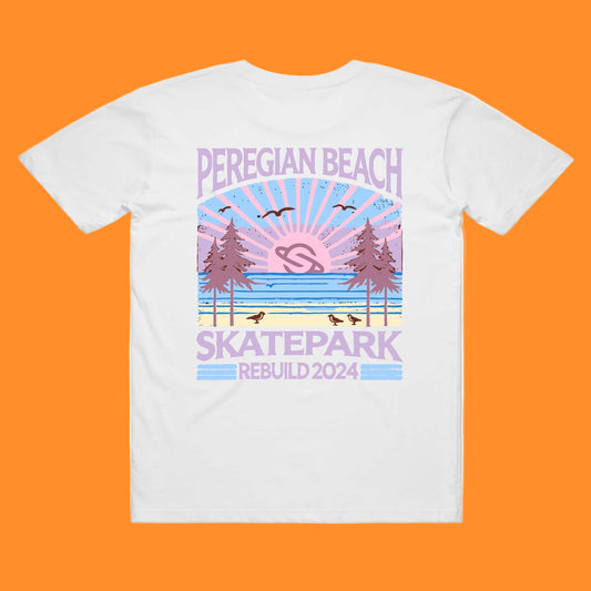 A white t-shirt with a printed design featuring the text 'PEREGIAN BEACH SKATEPARK' and a graphic of a sunset over a skatepark with birds and trees.